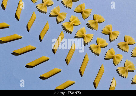 two kinds of macaroni on the blue table, design concept. creativity, sorting macaroni Stock Photo