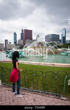 Female tourist looking at the Buckingham Fountain in Grant Park of Chicago Stock Photo