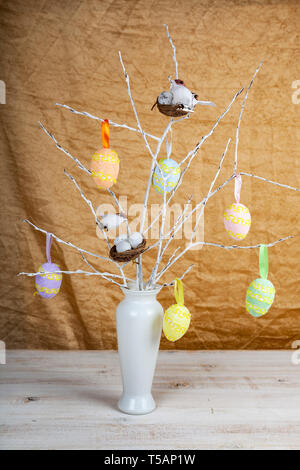 Easter eggs and bird nests on the branches. Easter decor in a vase. Stock Photo