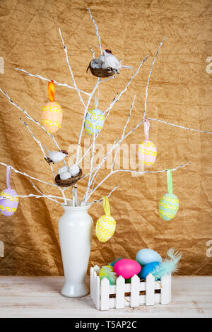 Easter eggs and bird nests on the branches. Easter decor in a vase. Stock Photo