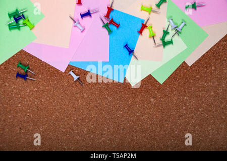 Corkboard with notes. Colored paper on corkboard. Stock Photo