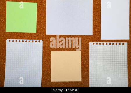 Corkboard with notes. Colored paper on corkboard. Stock Photo