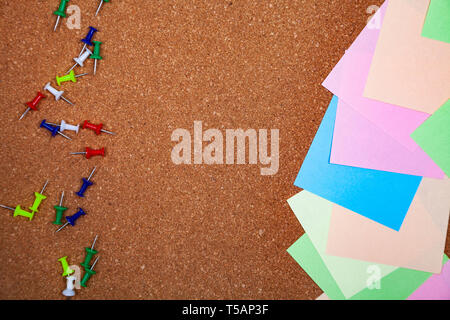 Corkboard with notes. Colored paper on corkboard. Stock Photo