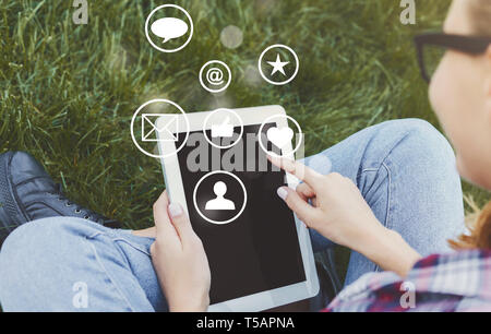 Woman touching tablet screen with virtual icons Stock Photo
