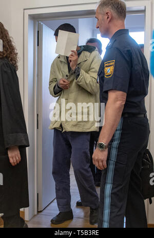 Amberg, Germany. 23rd Apr, 2019. One in four defendants enters the hearing room of the District Court of Amberg. Four young refugees have to answer in court because at the end of last year they allegedly attacked indiscriminately passers-by in the city centre of Amberg. Credit: Armin Weigel/dpa - ATTENTION: person(s) was/are pixelated for legal reasons/dpa/Alamy Live News Stock Photo