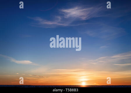 Bright colored winter sunset. Yellow clouds on the horizon and blue sky Stock Photo