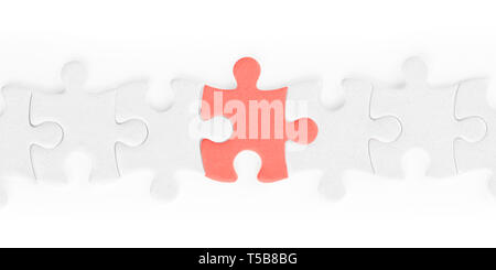 White jigsaw puzzle pieces row with red one isolated on white, clipping path included Stock Photo