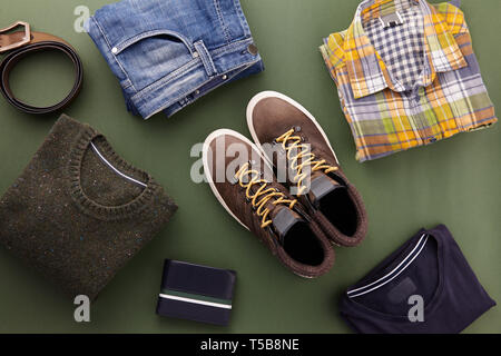 Mens fall casual clothing outfits and accessories flat lay on olive green background, top view Stock Photo