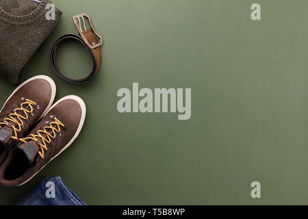 Mens fall casual clothing outfits and accessories flat lay on olive green background, top view Stock Photo