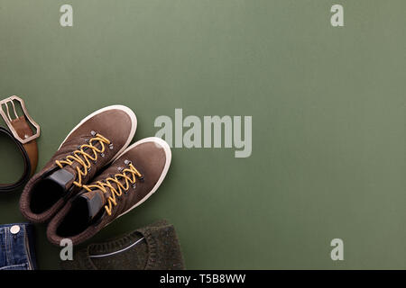 Mens fall casual clothing outfits and accessories flat lay on olive green background, top view Stock Photo