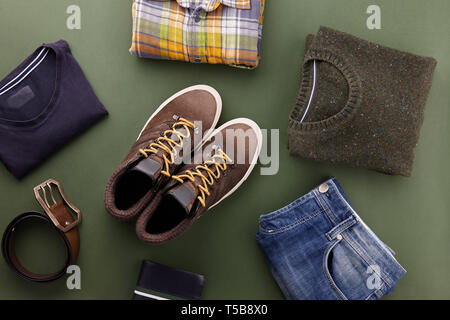 Mens fall casual clothing outfits and accessories flat lay on olive green background, top view Stock Photo