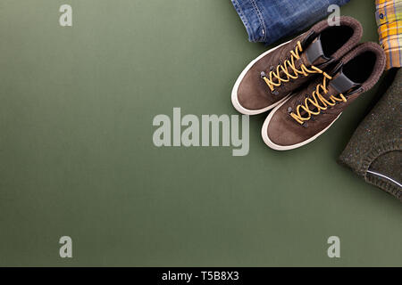 Mens fall casual clothing outfits and accessories flat lay on olive green background, top view Stock Photo