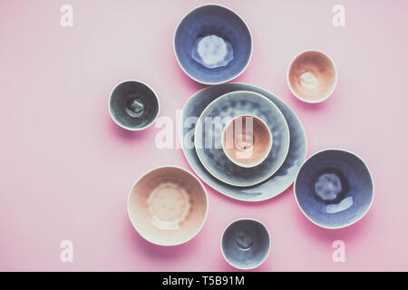Beautiful blue, grey, beige dinnerware, plates bowls on lilac table, top view, toned, selective focus Stock Photo