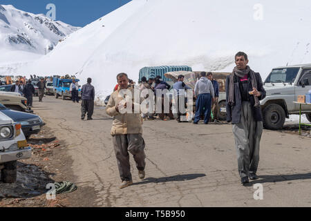 Smugglers Walking Through Roadside Bazaar In Uraman Valley In Winter, Kurdistan Province, Iran