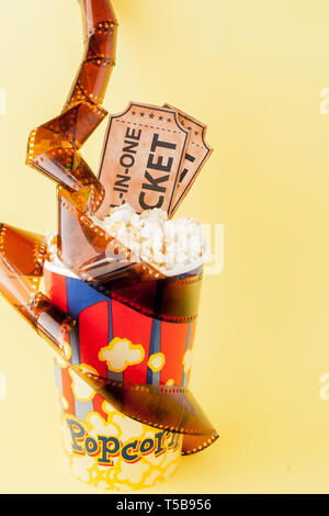 Movie tickets, film strips and popcorn on blue background. Copy space for text. Stock Photo