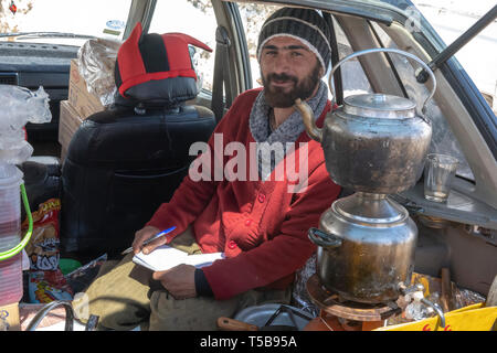 Smuggler Selling Tea Inside Car In Winter At Roadside Bazaar In Uraman Valley, Kurdistan Province, Iran