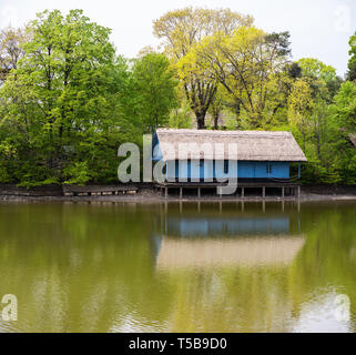 Fisherman hut on the Herastrau lake at day time. Shot from across the lake. Beautiful traditional romanian architecture Stock Photo