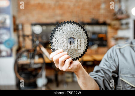 Repairman holding rear gear stars before installing them on a mountain bicycle at the workshop Stock Photo