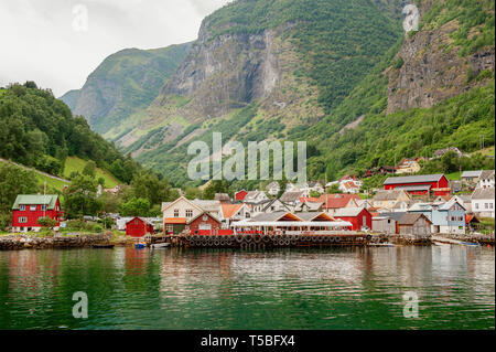 Small houses of the commune on the fjord, photographed from a sightseeing cruise ferry departing in summer from Flam, Norway view of a village on edge Stock Photo