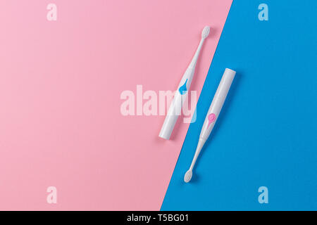 Two toothbrushes on blue and pink background. Top view Stock Photo