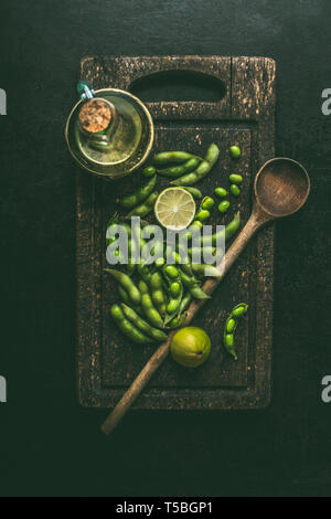 Green edamame soybeans on wooden cutting board with cooking spoon , top view. Healthy vegetarian food Stock Photo