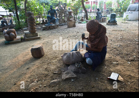 Female art student carving a wooden sculpture in the art university campus where she is studying ( India) Stock Photo