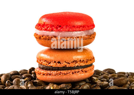 ower of macoroons on a pile of coffee beans on white background Stock Photo