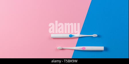 Two toothbrushes on blue and pink background. Top view Stock Photo