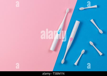 Two electric toothbrushes with brush heads on blue and pink background Stock Photo
