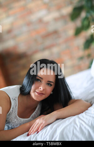 Beautiful girl lying on a bed in clothes Stock Photo