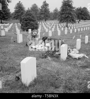 Two Women Decorating Soldier's Grave on Memorial Day, Arlington National Cemetery, Arlington, Virginia, USA, Esther Bubley for Office of War Information, May 1943 Stock Photo