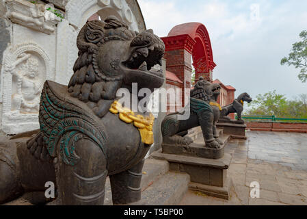 Lion guards near the buddhist monastery during an overcast spring morning at the monkey temple (Swayambhunath temple) in Kathmandu, Nepal Stock Photo