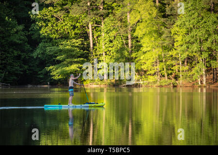 Active senior paddleboarding on a calm lake at Stone Mountain Park in Atlanta, Georgia. (USA) Stock Photo