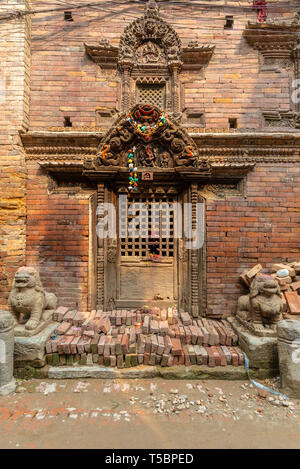 Old ornamented newari style door taken during a partly sunny afternoon in the historical center of Bhaktapur, Nepal Stock Photo