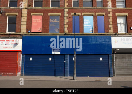 Blue closed Shop front blue security roller shutters on shop facade in bury town centre with no people in lancashire uk Stock Photo