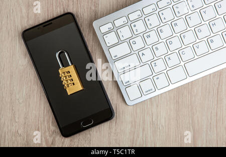 padlock on a smartphone with a computer keyboard top view Stock Photo