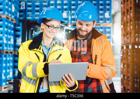 Woman and man as workers in logistics center using computer Stock Photo