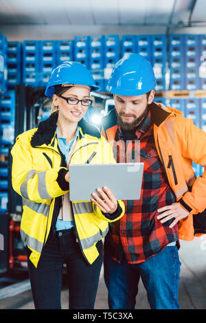 Woman and man as workers in logistics center using computer Stock Photo