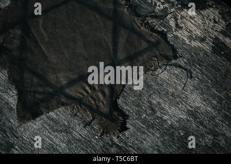 high angle view of a ragged jewish badge on a gray rustic wooden surface Stock Photo