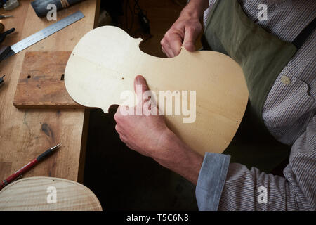 Violin maker at work in London, UK, carving the back of a violin Stock Photo