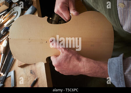 Violin maker at work in London, UK, carving the back of a violin Stock Photo