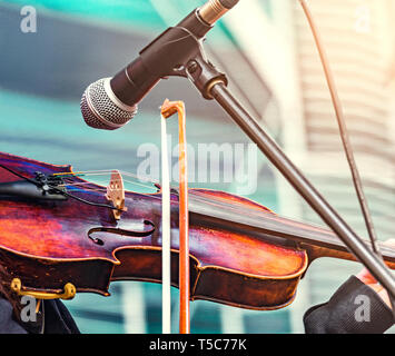 Violinist hands playing violin orchestra at evening time on the city square. Stock Photo