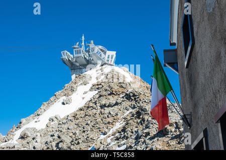 Cableway station Punta Helbronner shooted from Rifugio Torino with mountain and blue sky on the background and Italian flag Stock Photo