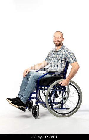 portrait of a smiling man sitting on a wheelchair and engaged in physical rehabilitation following an injury. Stock Photo