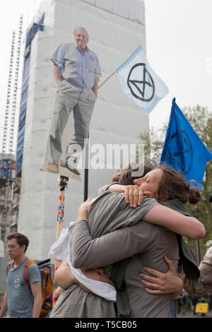 An image of veteran wildlife and environmental broadcaster Sir David Attenborough is held high in Parliament Square during the week-long protest by climate change activists with Extinction Rebellion's campaign to block road junctions and bridges around the capital, on 23rd April 2019, in London England. Stock Photo