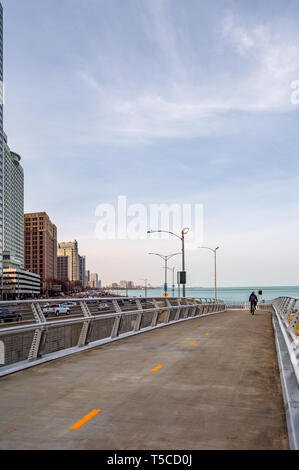 A cyclist is riding on the Lakefront Flyover along Lake Shore Drive. Main streets in Chicago, streets in Illinois. Stock Photo