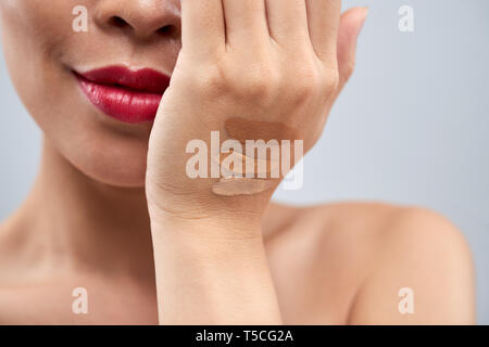 Concealer swatches on heand of woman Stock Photo