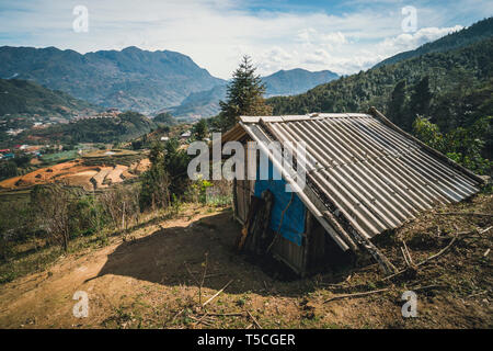 Landscape with a hut in the paddy rice terraces. Poor old dwelling in the mountains on the background of rice terraces in Sapa Vietnam. Stock Photo