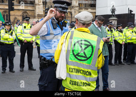 London, UK. 23rd April 2019. A climate change activist from Extinction Rebellion speaks to a police liaison officer in front of a police cordon in Parliament Square positioned to prevent fellow activists from Extinction Rebellion from attempting to deliver letters to Members of Parliament requesting meetings to discuss the issue of climate change. Credit: Mark Kerrison/Alamy Live News Stock Photo