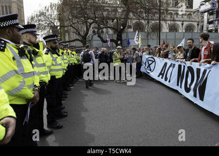 London, Greater London, UK. 23rd Apr, 2019. Extinction Rebellion activists are seen behind a large banner marching to Parliament to deliver letters to their MPs during the Extinction Rebellion march in London.Extinction Rebellion protesters march from Marble Arch to Parliament Square, attempting to deliver letters to their MPs. Extinction Rebellion activists were permitted to be in Parliament Square but not to enter Parliament. After several attempts to deliver the letters, the activists reached an agreement with MPs through the police. Ten activists were allowed to deliver the Stock Photo